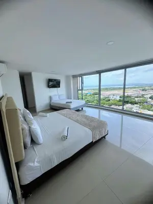 a bedroom with a large bed and a large window at Penthouse vista panoramica frontal al mar 450 mts2 in Cartagena de Indias