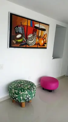 a living room with a pink ottoman and a painting at Penthouse vista panoramica frontal al mar 450 mts2 in Cartagena de Indias