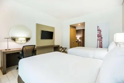 a hotel room with two beds and a mirror at Hilton Garden Inn Barranquilla in Barranquilla