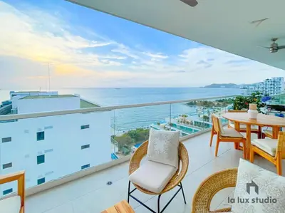 a balcony with a table and chairs and the ocean at Moderno 3 hab con la mejor Vista en playa dormida Santa Marta in Santa Marta