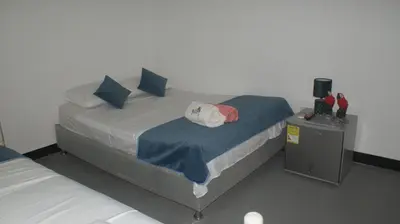a bed with blue pillows and a white pillow on it at Guacamayas in Santa Marta