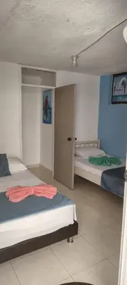 a bedroom with two beds and a door in it at Guacamayas in Santa Marta