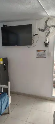 a room with a tv and a fan on a wall at Guacamayas in Santa Marta