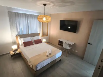 a bedroom with a bed and a desk and a television at 2BR Oceanfront Apartment - Direct Beach Access - Modern and Spacious - 6th Floor in Cartagena de Indias