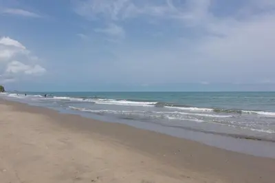 a beach with the ocean and people in the water at Lujoso Apartamento Con Salida Directa A La Playa Edificio Morros Eco in Cartagena de Indias
