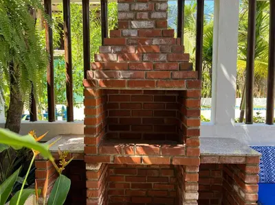 a brick fireplace in a porch with a staircase at Casa El Faro, Hermosa casa de playa in Cartagena de Indias
