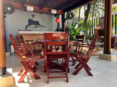 a wooden table and chairs on a patio at Casa El Faro, Hermosa casa de playa in Cartagena de Indias