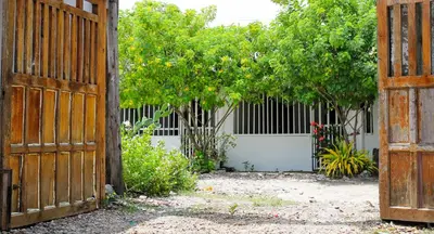 an open wooden gate with trees and a fence at Apartamento a unos pasos de la playa in Cartagena de Indias