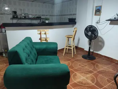 a living room with a green couch and two chairs at Apartamento a unos pasos de la playa in Cartagena de Indias