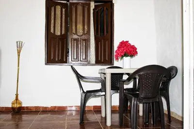 a dining room table with two chairs and a vase of flowers at Apartamento a unos pasos de la playa in Cartagena de Indias