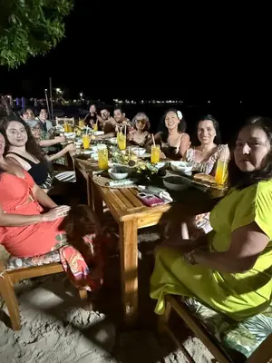 a group of people sitting at a table on the beach at Thani Ecobeach Barú in Playa Blanca