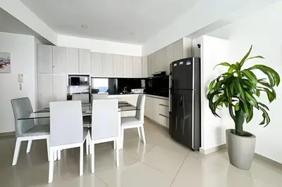 a kitchen with a dining table and a black refrigerator at Apartamento 2 Dormitorios Laguito. Vista Mar in Cartagena de Indias