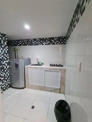 a white kitchen with a sink and a refrigerator at Apartamentos La Marina in Cartagena de Indias