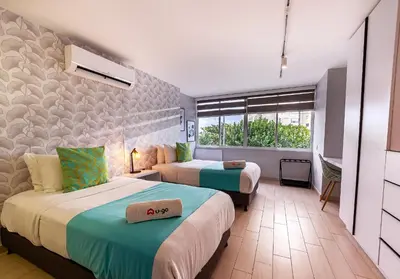 a hotel room with two beds and a window at U-GO Edificio Faro en El Laguito, Cartagena in Cartagena de Indias