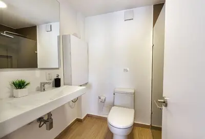 a white bathroom with a toilet and a sink at U-GO Edificio Faro en El Laguito, Cartagena in Cartagena de Indias