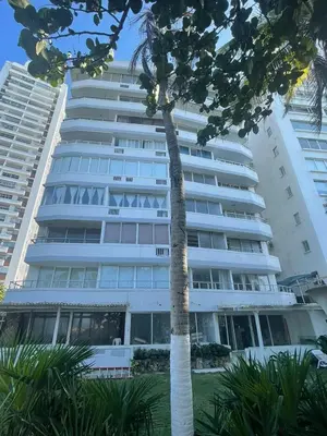 a tall white building with a palm tree in front of it at U-GO Edificio Faro en El Laguito, Cartagena in Cartagena de Indias