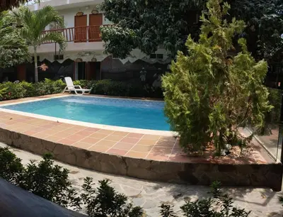 a swimming pool in front of a house at Hostal Los Arhuacos in Santa Marta