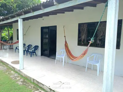 a patio with chairs and hammocks on a house at Mágica Cabaña familiar cerca al mar in Coveñas