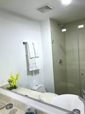 a bathroom with a shower and a toilet and a mirror at Sensacional Apartamento nuevo frente al mar in Cartagena de Indias