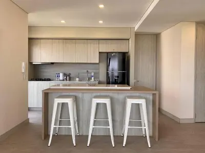 a kitchen with a bar with three stools at MQ 1006 Cartagena, Playa cercana in Cartagena de Indias