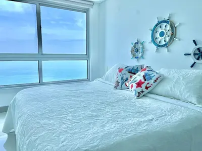 a bedroom with a bed with pillows and a window at by Calamari Homes - Palmetto Beach 2504 Bocagrande in Cartagena de Indias