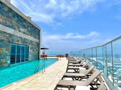a swimming pool on the roof of a building with chairs at by Calamari Homes - Palmetto Beach 2504 Bocagrande in Cartagena de Indias