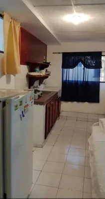a kitchen with a refrigerator and a table and a window at Cecil Aparta Estudios in Barranquilla