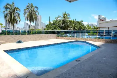 a swimming pool in a building with palm trees at Hermoso Apartamento vista al mar El Laguito in Cartagena de Indias
