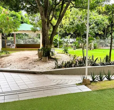 a park with a tree and a white fence at Apartamentos Condominio Oporto - Cerca a Todo in Barranquilla