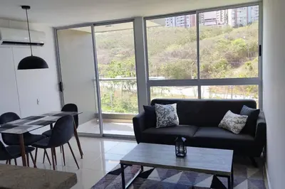 a living room with a couch and a table at Hermoso y acogedor apartamento al norte de Barranquilla sector BUENAVISTA in Barranquilla