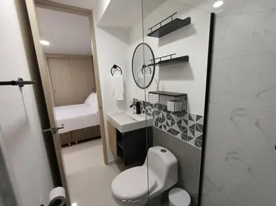 a bathroom with a toilet and a sink and a mirror at Moderno apartamento al norte de Barranquilla in Barranquilla