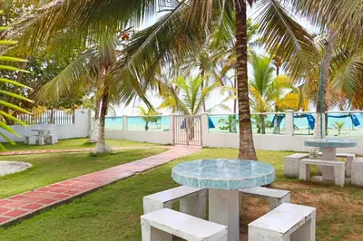 a table and benches in a park with palm trees at Magico Apartamento Frente al Mar 3 Habitaciones C11A in Coveñas