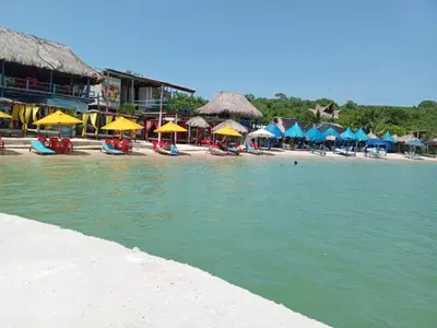 a beach with chairs and umbrellas on a beach at casa de vacaciones tierra bomba cartagena de indias in Tierra Bomba