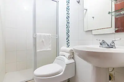 a white bathroom with a toilet and a sink at Ayenda Casa Amarilla in Santa Marta