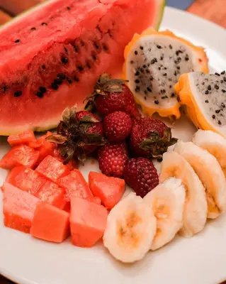 a white plate with fruit on a table at Hb3 Double Room with private bathroom facing the sea in Cartagena de Indias