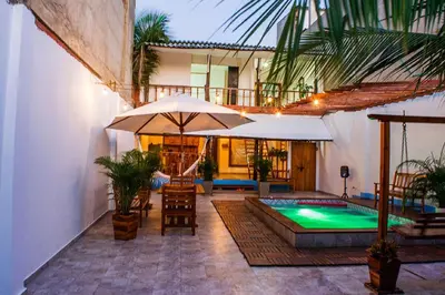 a patio with a pool and an umbrella and chairs at Hb3 Double Room with private bathroom facing the sea in Cartagena de Indias