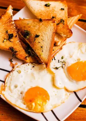 a plate of eggs and toast and bread on a table at Hb2 Triple Room with shared bathroom in Cartagena de Indias