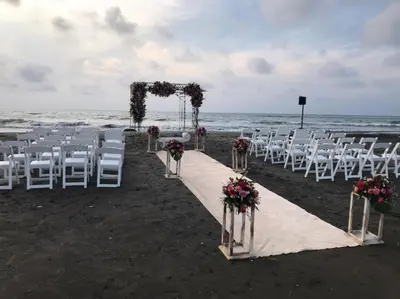 a wedding ceremony on the beach with white chairs and flowers at Casa Bita Morales CASA 201 in Cartagena de Indias