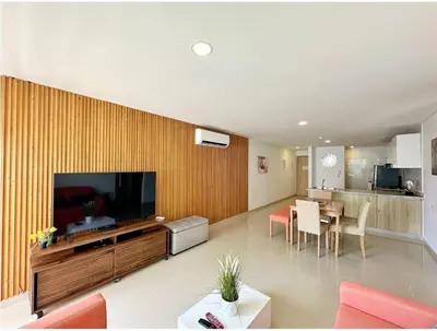 a living room with a large television and a dining room at Acogedor Marbella ideal familias mínimo 2 días in Cartagena de Indias