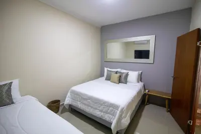 a bedroom with two beds and a mirror at Casa Palmar Cartagena in Cartagena de Indias