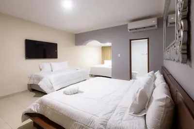 a bedroom with two beds and a flat screen tv at Casa Palmar Cartagena in Cartagena de Indias