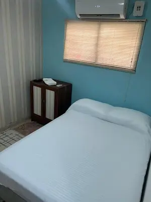 a bedroom with a white bed and a blue wall at Beach Airport House in Cartagena de Indias