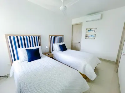 two beds in a room with white and blue at Magico Apartamento Frente al Mar 4 Habitaciones O62 in Coveñas