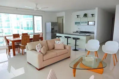 a living room with a couch and a table and a kitchen at Magico Apartamento Frente al Mar 4 Habitaciones O62 in Coveñas