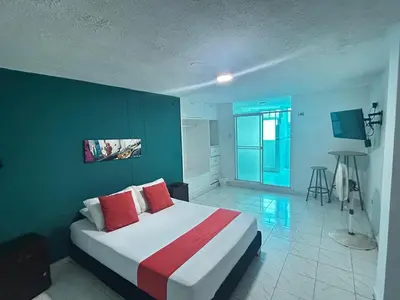a bedroom with a large bed with red pillows at Hotel Boston Superior in Barranquilla