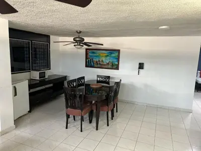 a dining room with a table and chairs and a ceiling fan at Hotel Boston Superior in Barranquilla