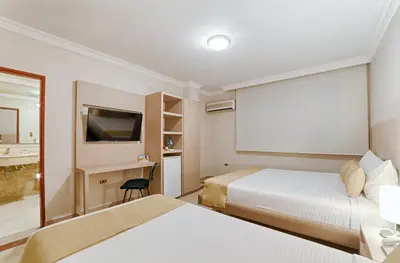 a hotel room with two beds and a flat screen tv at Hotel Caribe 79 in Barranquilla