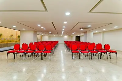 a row of red chairs in a large room at Hotel Caribe 79 in Barranquilla