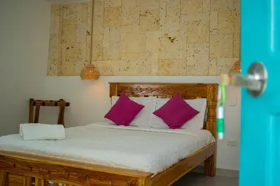 a bed with purple pillows in a room at Casa Playa James in La Boquilla