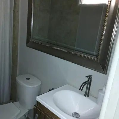 a bathroom with a sink and a toilet and a mirror at Capitel Hostel in Cartagena de Indias